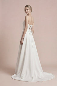 Load image into Gallery viewer, Straplez A kesim saten gelinlik modeli, drapeli üst beden ve bağcıklı açık sırt detaylı modern AKAY Bridal gelinli
