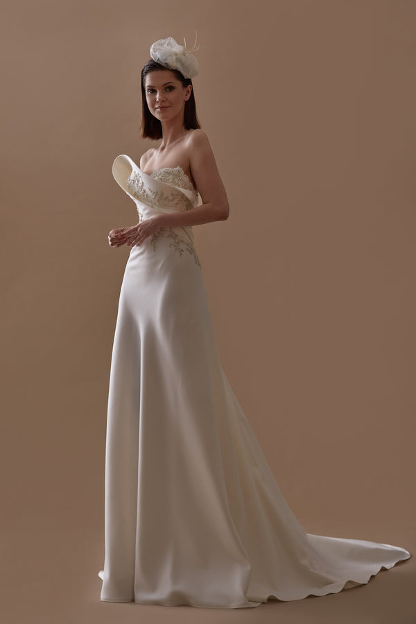 Akay saten ve straplez balık kesim düğün gelinliği, vücut formunu ön plana çıkaran dar kesimli tasarım ve zarif etek detaylarıyla modern gelinlik
